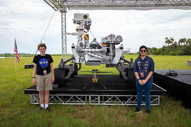 Students Alex Mather, at left, and Vaneeza Rupani, stand near the countdown clock at the News Center at NASA’s Kennedy Space Center in Florida on July 28, 2020. Mather named the Perseverance rover, and Rupani named the Ingenuity helicopter.