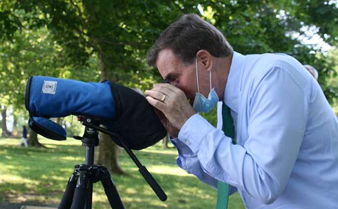 Sen. Mark Warner checks out an osprey off the shores of Belle Haven Park, visiting to talk about bipartisan support for the Great American Outdoors Act.