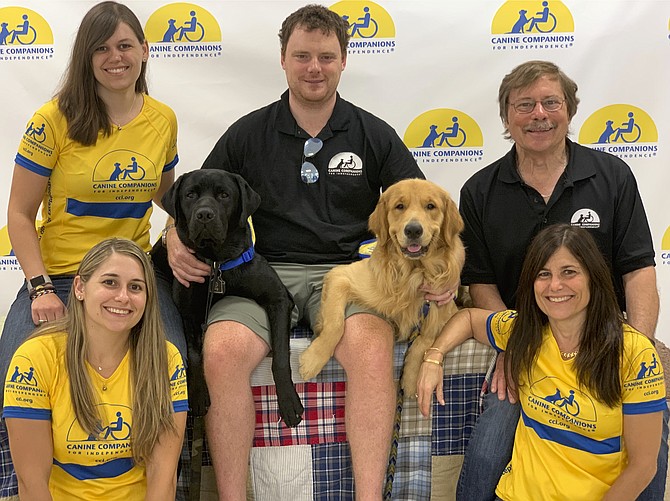 The Cheshire family of Great Falls with the dogs they raised, Buckner, the black Lab, and Zeno, the Golden Retriever. Top, from left: Nikki Cheshire, Raymond Junkins and Ben Cheshire. Bottom, from left: Tory Junkins and Jacqueline Cheshire.