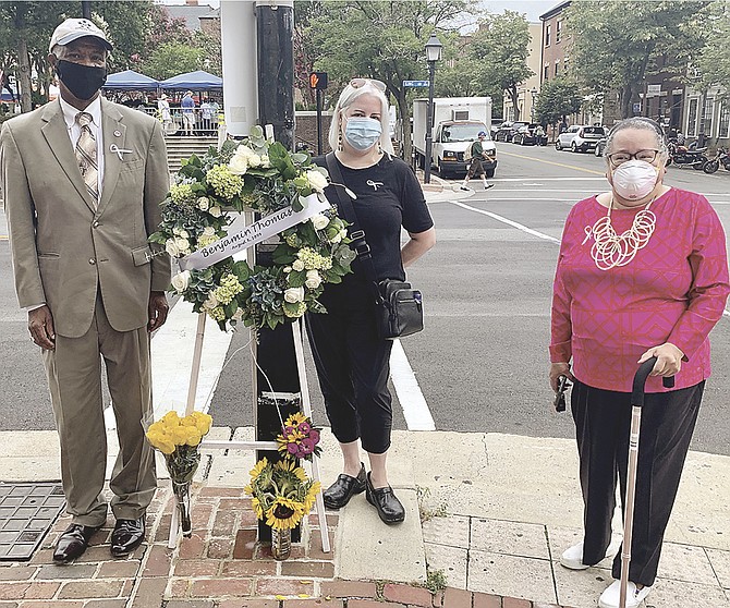 McArthur Myers, Maddie McCoy and Audrey Davis, director of the Alexandria Black History Museum, stand at the corner of King and Fairfax streets Aug. 8 to commemorate the 121st anniversary of the lynching of 16-year-old Benjamin Thomas in 1899.