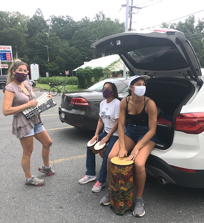 Volunteers Sunny Trippel, left, and Chloe Maciejewski, right, work out a percussion tune with Deb Lang, executive director of KindWorks, with donated instruments. The group held an instrument collection Saturday in Glen Echo. All donations will go to students in need.