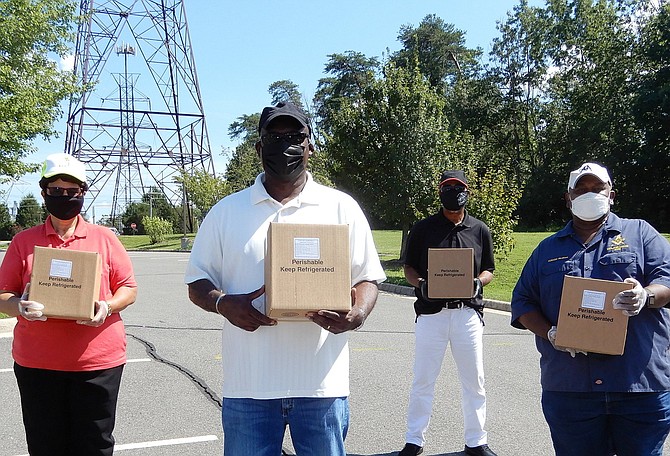 (From left) Mount Olive Baptist Church volunteers Sandra Chew, Roland Williams, Rubin Cuffee and Tony McGhee with food boxes to distribute.