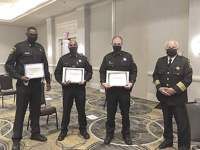 Sheriff Dana Lawhorne, right, stands with Deputy Jason Bebow, Deputy Devon Neckles and Deputy Julio Ocasio after the trio received life-saving awards during the Chamber ALX 2020 Valor Awards Aug. 27 at the Hilton Old Town Alexandria.