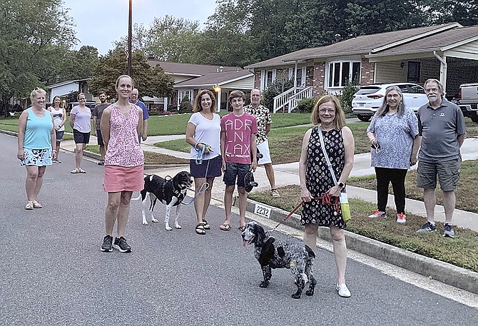 Residents of the Williamsburg Manor North neighborhood gather to listen to retired Navy Master Chief Paul Johnson perform Taps at sunset Aug. 21.