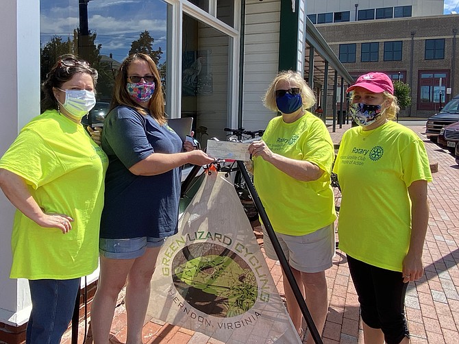 (From back left) Beth Meyer, co-owner of Green Lizard Cycling, presents a donation check to benefit LINK, Inc. to Peggy O'Reilly of Rotary Satellite Club of Herndon during Rotary's Food Drive held Saturday, Sept. 5. (From front left) Rotarians Signe Friedrichs and  Kristen Spotz look on.