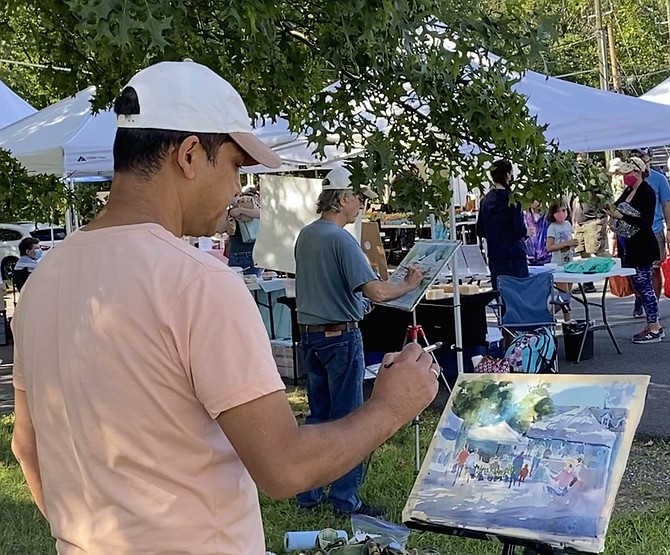 Artists (back to front) Robert Gilbert of Great Falls and Rajendra KC of Falls Church at the Saturday Great Falls Community Farmers Market.