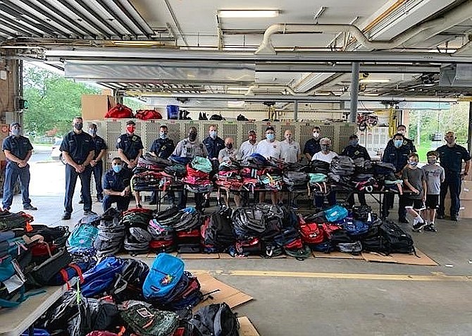 Volunteers gather at Penn Daw Fire Station 11 Aug. 31 to distribute more than 1,100 backpacks filled with school supplies for families throughout the county.