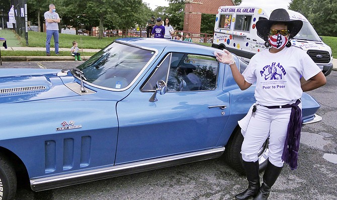 Titilayo Abdu-Salam stands by a classic Corvette. “It’s not my car but I love it.” Abdu-Salam is at the event with Arm & Arm to help reach Arlington community members who have not yet registered for the census.