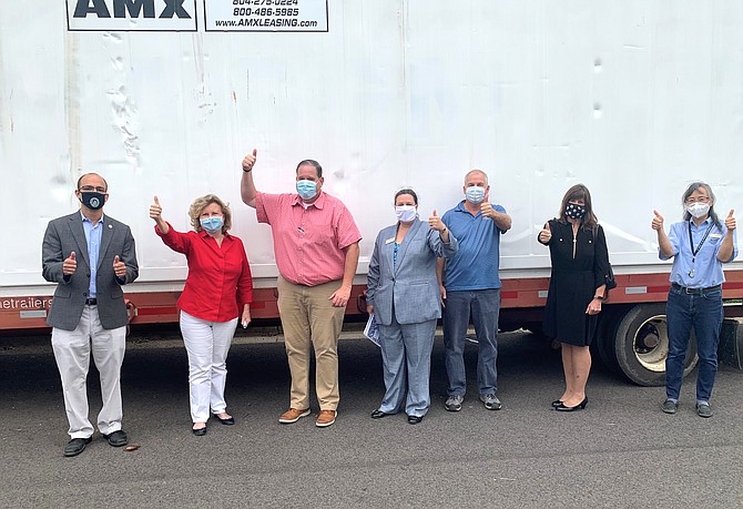 ALIVE! executive director Jennifer Ayers, center, celebrates the donation of a refrigerated shipping container by AMX Leasing & Logistics Sept. 14 on the grounds of AlexRenew. Picture with Ayers are (l-r) Mayor Justin Wilson, Marion Moon, Mel Lynn of AMX, Steve Bransford, Kate Garvey and Ann Patterson.