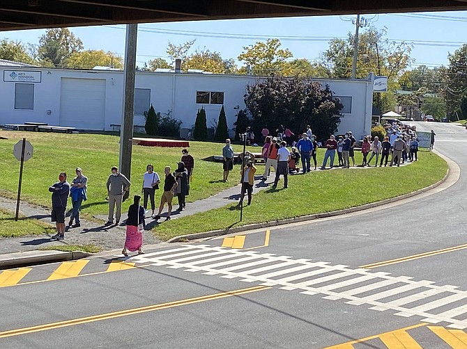 The voting line in Herndon stretches from inside the Herndon Fortnightly Library, outside the building, under the W&OD Trail overpass, up Center Street (as seen in the photo), turns onto Vine Street and continues into the municipal parking lot.