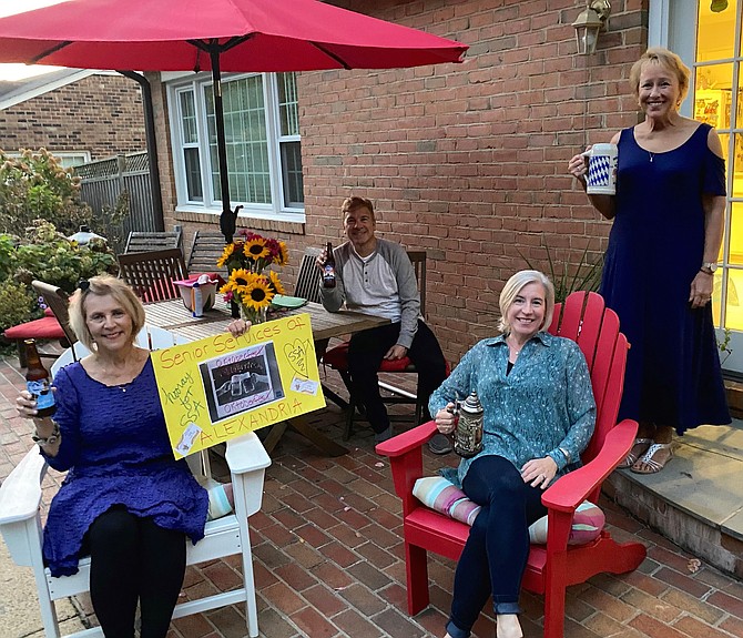 Janet Barnett, left, holds a sign celebrating the Oct. 15 Senior Services of Alexandria Oktoberfest. Barnett hosted an in-home gathering for the virtual event. She is joined by Mitch Opalski of Synergy Home Care, Cecile Garrett of At Home in Alexandria and Pam Phillips of Sunrise of Alexandria.