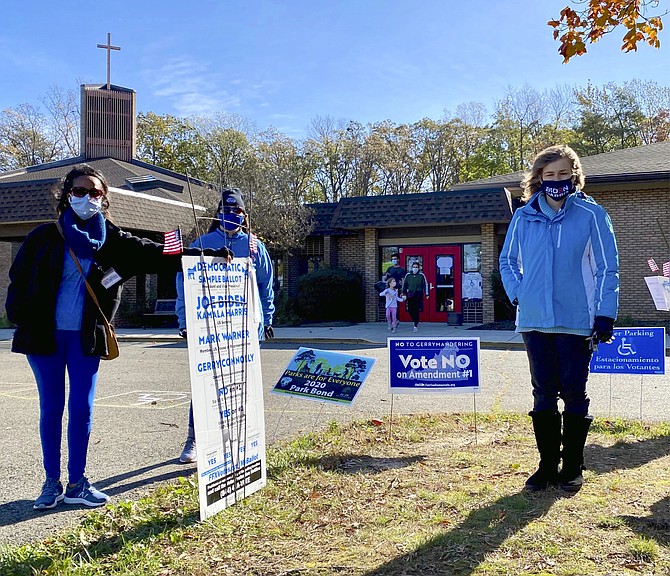 Democratic Party committee poll watchers offered a sample ballot card instead of hand-out information in a nod to Covid-19 safety, here at Pohick Precinct, and polling places throughout Fairfax County. Republican Party workers used the traditional written sample ballot method.