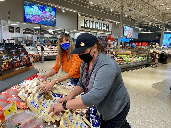 Cheese company vendor, Mary Lyon, Fredericksburg; and Giant employee, Jennifer Parker, Spotsylvania; arrange cheese products located near the spacious prepped foods kitchen area.