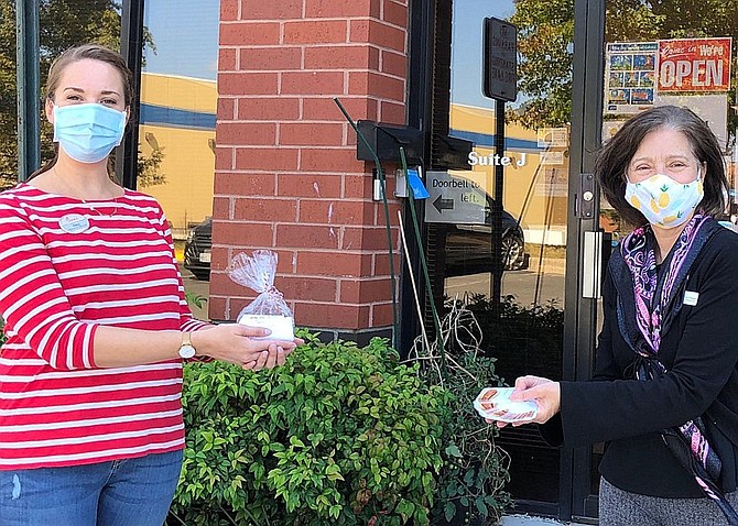 (From left) Chick-fil-A Marketing Director Amy Allen hands gift cards to WFCM Development Director Mary Ellen D'Andrea.