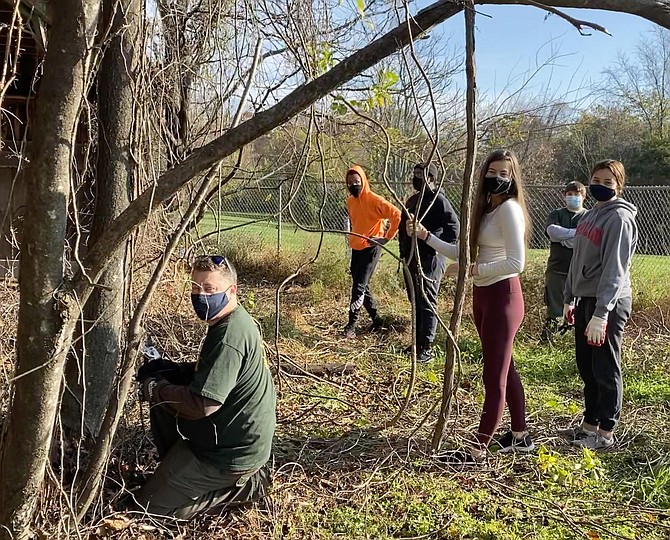 Laurel Hill Park volunteers clear invasive vines from a fence obscuring the historic turkey barn: Shawn Elklund, Justin Barnes, Joshua Miller, Livia Davidson, Grace Ametin, Caleb Elkund; also Nico Valckx (not pictured).