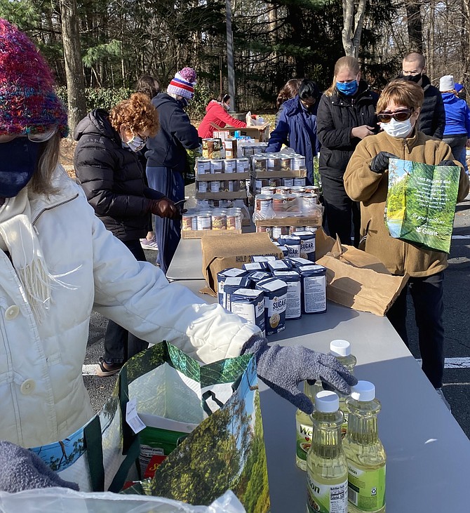 Volunteers line up all the food items to go into bags on one long counter making for an easy assembly line process.