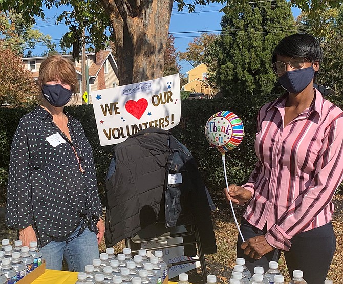 Senior Services of Alexandria staff members MaryAnne Beatty, left, and Tanya Edwards man the water station during the Meals on Wheels volunteer appreciation drive-through luncheon Nov. 6 at the First Baptist Church of Alexandria.