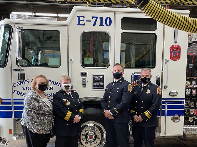 At the dedication of the new engine:  Mary Seavey, CJPVFD Chief Corinne Piccardi, James Seavy Jr. and Acting Fire and EMS Chief John A. Donnelly Sr. of the D.C. Fire Department, next to Cabin John's new fire truck at its dedication ceremony Saturday. The truck was dedicated in honor of former CJPVFD Chief James P. Seavey Sr.