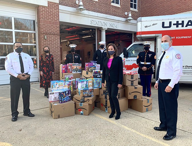 Fire Chief Corey Smedley, left, and Assistant Fire Chief Michael Cross, right, stand with members of the U.S. Marine Corps and Toys for Tots organizers after more than 2,000 toys were dropped off Dec. 10 at AFD headquarters for distribution to local families.