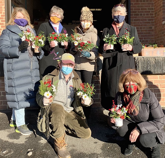 Red Hill Garden Club members (standing l-r) Jane Foote, Carter Flemming and president Monica Murphy join Senior Services of Alexandria Executive Director Mary Lee Anderson and Meals on Wheels coordinators Marshal Hespe and MaryAnne Beatty (kneeling) Dec. 17 at Jeffrey’s Catering. The club delivered 200 floral arrangements for delivery to SSA Meals On Wheels recipients.