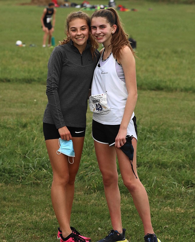 (From left)  Tea Geary, 15, of Herndon, teammate and friend, gives Gillian Bushée of Reston a hug after her winning cross country race.