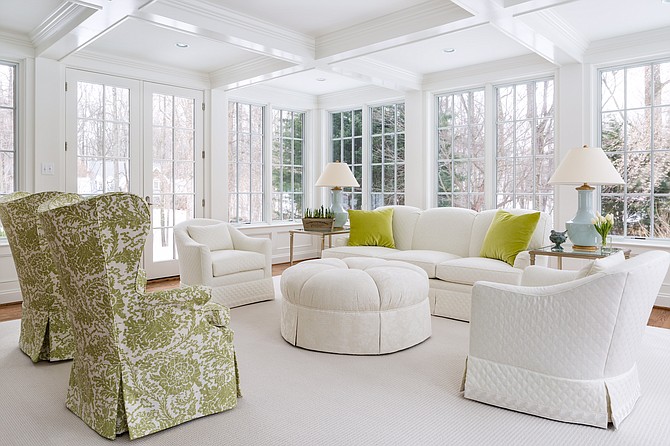 The Potomac, Maryland sunroom was redesigned by the Anthony Wilder team to include a coffered ceiling and classic green and white furnishings.