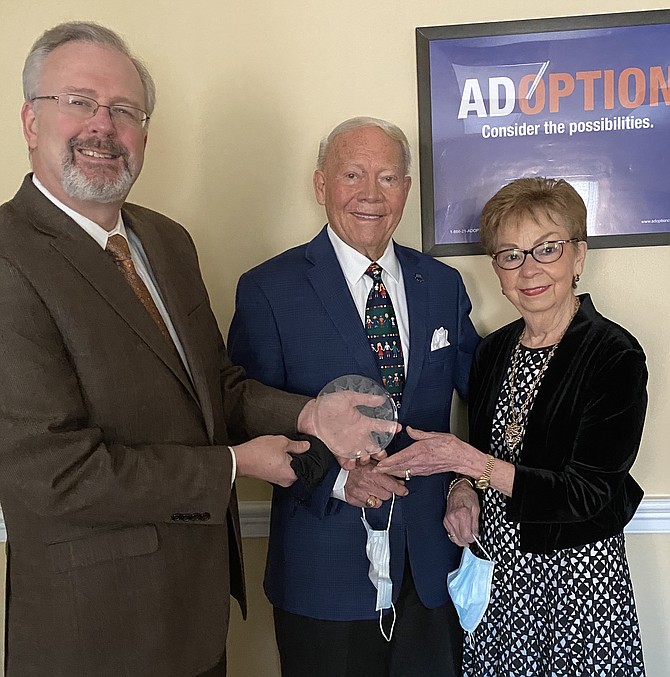 (From left) Chuck Johnson, President and CEO of the National Council For Adoption (NCFA) hands The Ruby Lee Piester  Award  to Linda Whitbeck Sharp of Mclean  and her husband,  Dr. Wayne Winston Sharp, Ph.D. The award is named after Ruby Lee Piester, founder of NCFA.