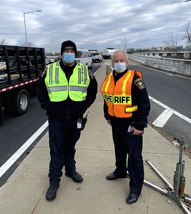 Alexandria Sheriff Dana Lawhorne, right, and Sheriff Lt. Daniel Gordon stand on the Virginia side of the 14th Street Bridge Jan. 19 as Alexandria Sheriff’s Office deputies oversee the closure of the bridge during the Presidential Inauguration.