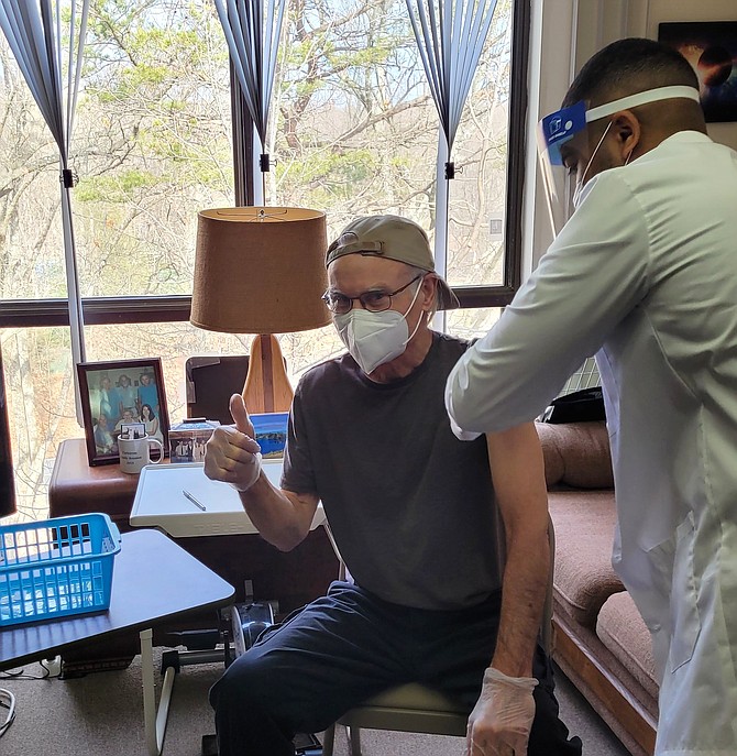 Lake Anne Fellowship House resident Steve McAvoy, 71, receives his long-awaited COVID-19 vaccine from a mobile health team with CVS pharmacy.