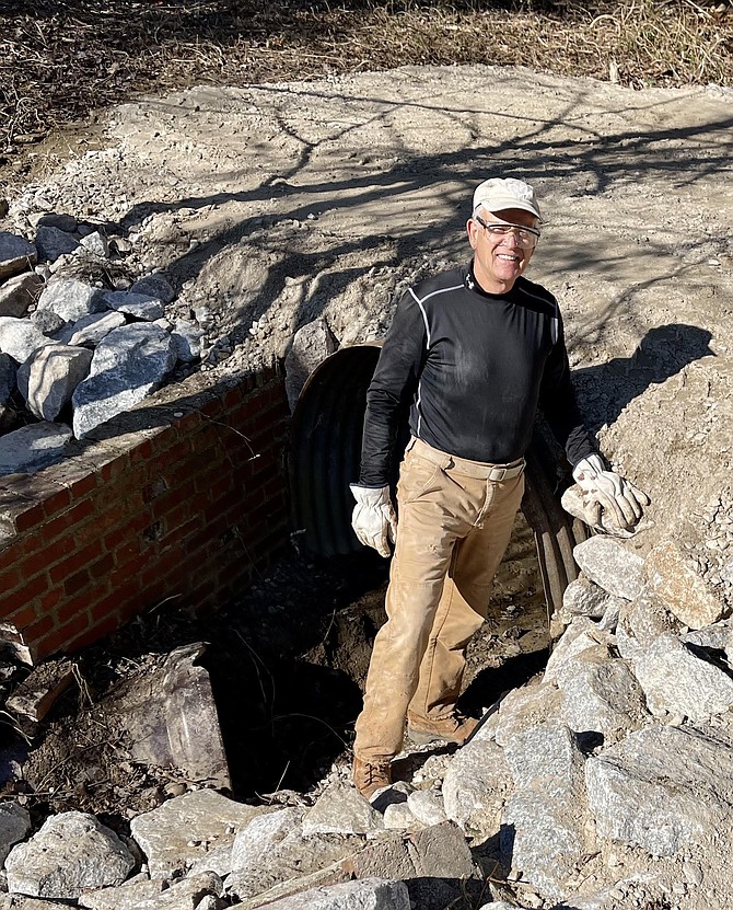 Laurel Hill Park volunteer Michael Applegate stands at his hand-dug rock wall lining creek drainage.