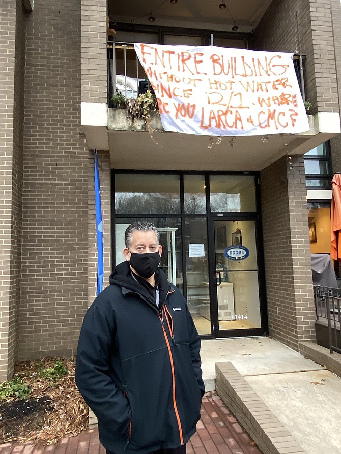 Matt Jordan and his wife, Robin (not pictured), spray-painted their protest banner and hung it off the railing of their condominium. Their unit happens to be one unit away from Lake Anne Brew House, owned and operated by Jason Romano, who some people call the “disputed” President of the Lake Anne Reston Community Association (LARCA), that Community Management Corporation, CMC, recognizes as President.