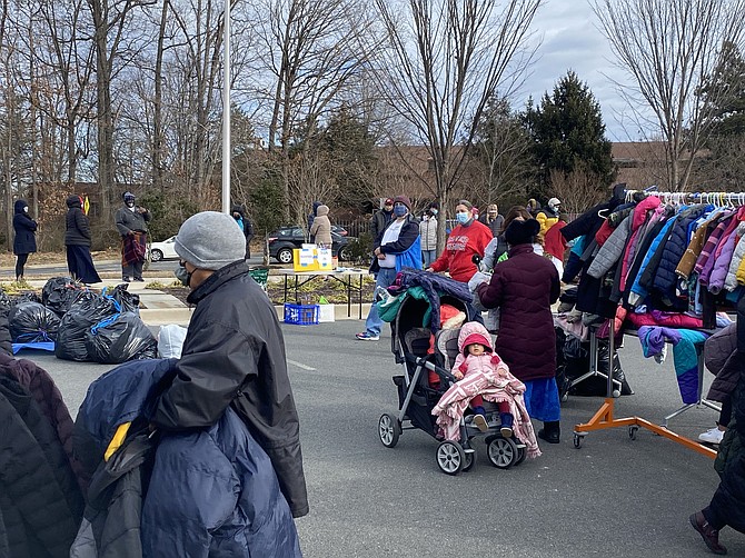 Individuals and families in need of winter outerwear select one coat and accessory for each household member at the Hunter Mill District Winter Coat Closet held outdoors during the 2020-21 season.
