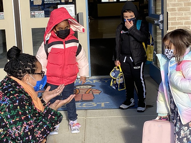 Principal Jill Stewart at Lake Anne Elementary School in Reston talks with children as they arrive for their first day of in-person learning at the school.