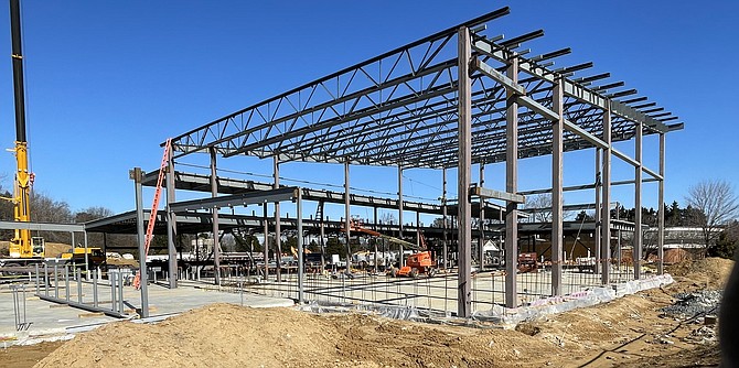 Steel beam outlines of the new Lorton community center dwarf the old library (right rear).