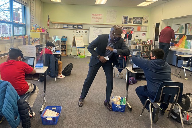 Alexandria City Public Schools Superintendent Gregory Hutchings gives an elbow bump greeting to a student March 2 at Mount Vernon Community School. ACPS students returned to in-person classes after nearly a year of virtual learning due to the COVID-19 pandemic.