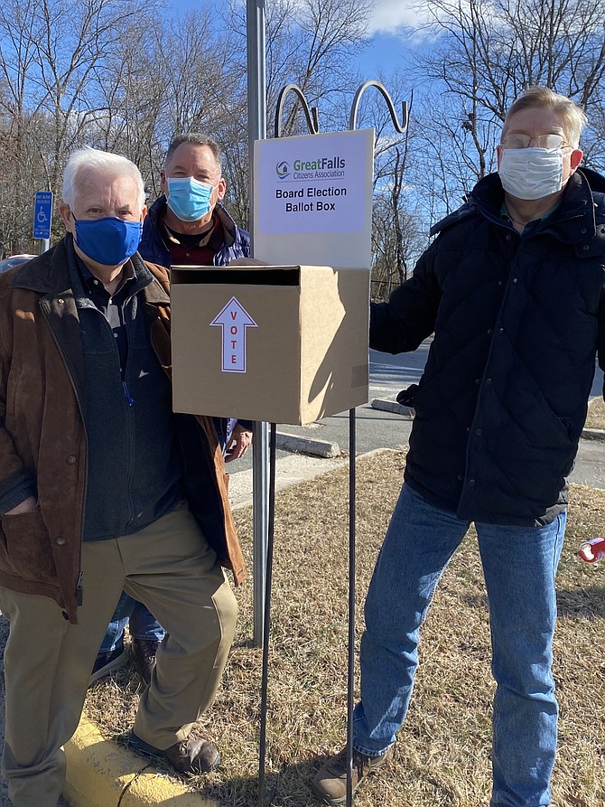 Members of Great Falls Citizens Association, Michael Barclay, Transportation Co-Chair; Ed Phillips, outgoing Vice President; and James Trent, Treasurer, Chair of Nomination, erect the drive-in-person ballot box in the parking lot of the Great Falls Library for the organization's 2021 Election held on March 6.