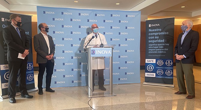 Inova Health Systems CEO Dr. J. Stephen Jones makes remarks during a March 9 preview of the high-capacity vaccination site at the Victory Center in Alexandria. With him are Fairfax County Board of Supervisors Chairman Jeff McKay, Alexandria Mayor Justin Wilson and Stonebridge Principal Douglas Firstenberg.