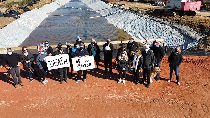 Vienna and Great Falls residents stand with their back to Colvin Run after the Virginia Department of Transportation realigned the waters into a paved trapezoidal channel near the confluence with Difficult Run as part of its Route 7 Improvements.