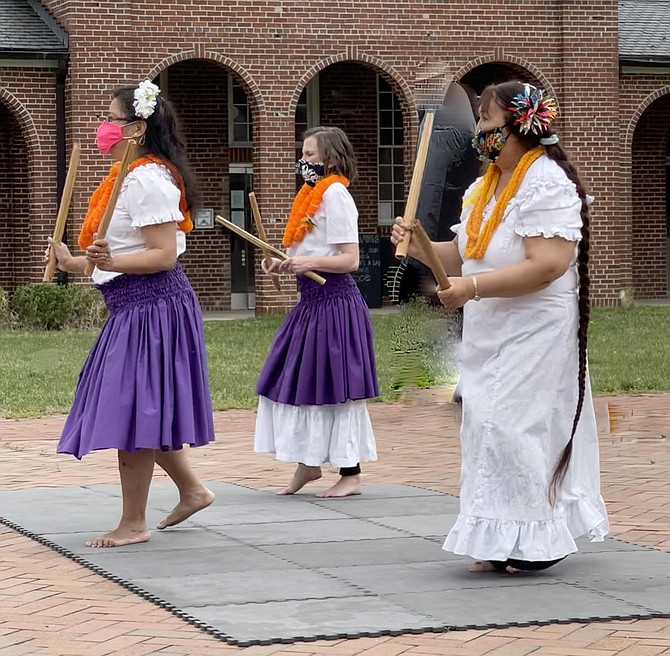 Nora Wong, of Bristol; Samantha Weinheiner, of Falls Church; and Cherry Nutting, of Fairfax, dance group instructor and leader, perform hula using pu’ili. Sticks made of bamboo, with slits cut in one end with strands removed, create a rattle when moved and hit against the body.