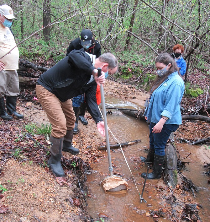 John Fagan scoops up sediments as Ashley Palmer gives guidance.