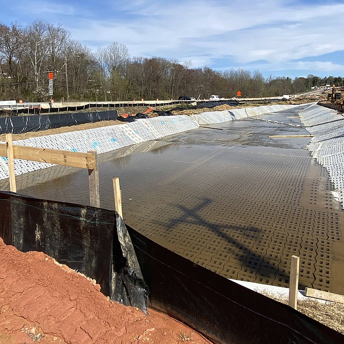 Colvin Run as an articulated concrete block channel with the addition of staggered weirs, wooden boards to dissipate the water velocity.