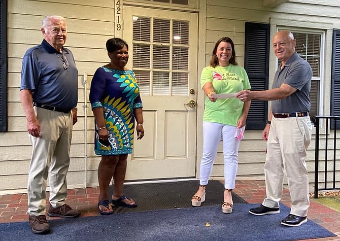 (From left) Rotary Club of Fairfax New Generations Director, Verne Tuininga, and Fairfax City Schools Superintendent Phyllis Pajardo look on while Kate Malesky of a Place to Stand receives a financial donation from Rotary Club of Fairfax President Barry Gordon.