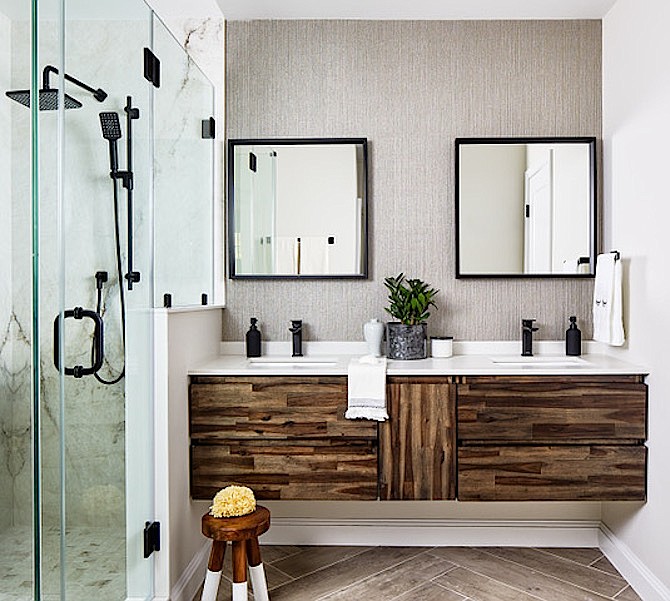 White countertop, dark wood cabinets, floating vanity, black fixtures create a spa-like atmosphere in this bathroom by InSite Builders & Remodeling.