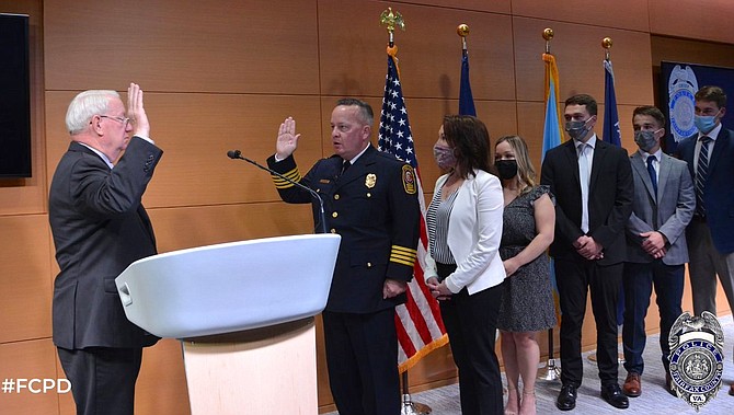 (From left) John T. Frey, the Fairfax County Circuit Court clerk, swears in Kevin Davis as the Chief of Police, Fairfax County Police Department, on Monday, May 10, 2021.