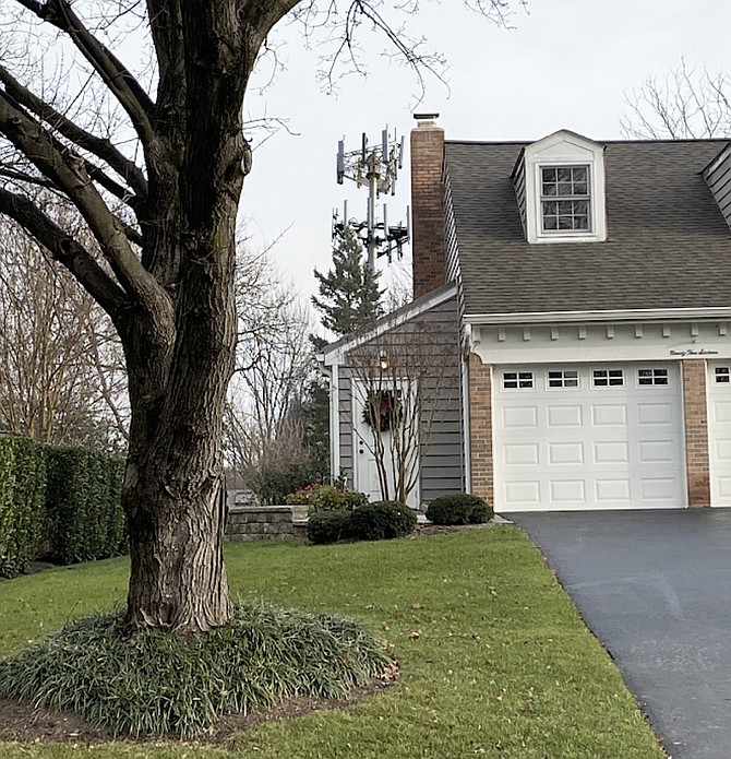 The photo illustration depicts the planned 114-foot telecommunications monopole tower. A proposed alternative could have been a 122-foot-tall tree pole monopine tower, with an additional 8 feet of faux tree branches. According to the homeowner near the corner of Bent Creek Lane and Stone Meadow Way in Vienna, the tower would have been visible to the left of the garage.