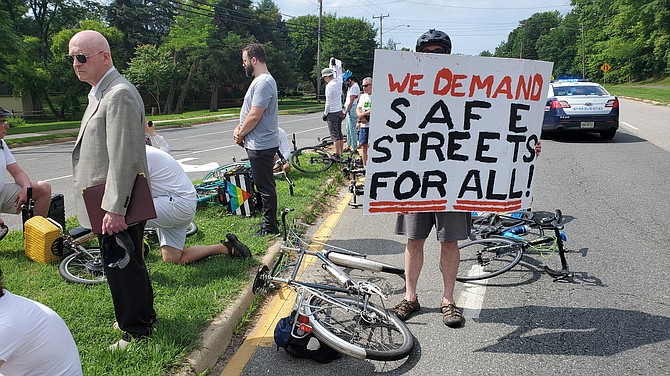 Bicyclists holding signs during a moment of remembrance at the crash site where Fatima Del Carmen Alvarez Romero was killed.