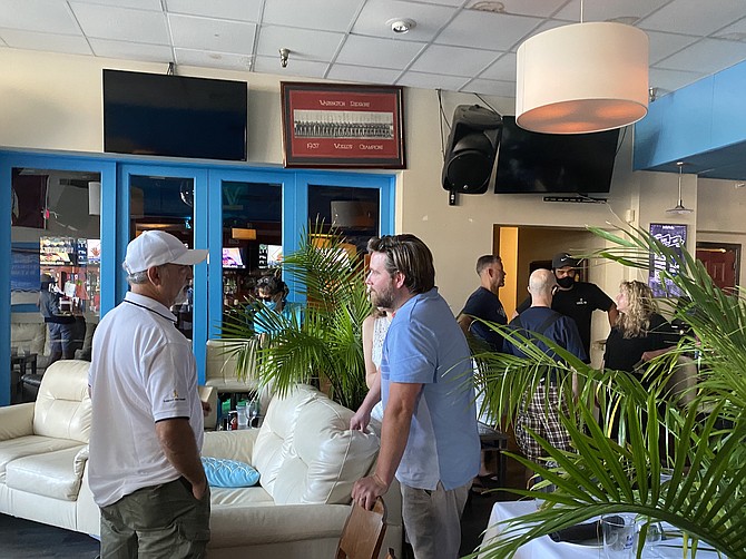 (From left front) Following what was to be a casual conversation between a few condo owners of the Quayside condominiums at Lake Anne Plaza impacted by a second extended no-hot-water issue and Supervisor Walter Alcorn (D-Hunter Mill), George Hadjikyriakou, owner of Kalypso's Sports Tavern on Lake Anne Plaza, talks with Matt Stevison, who lives at Quayside. The conversation with Alcorn turned to an unexpected group discussion between him and 27 people in attendance.