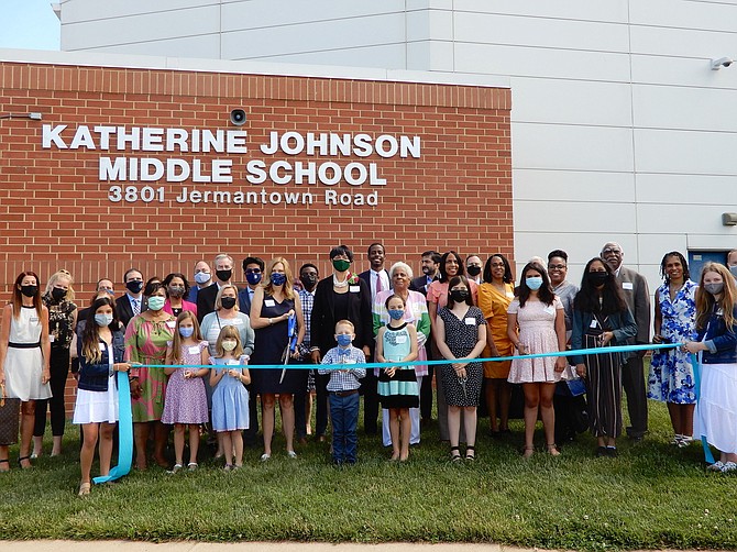 Surrounded by students, dignitaries and Johnson family members, Principal Tammy Hanna is about to cut the ribbon on the school.