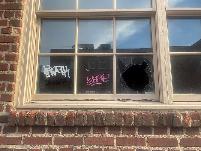 Broken windows and graffiti on a building at the corner of Prince and S. Washington streets.