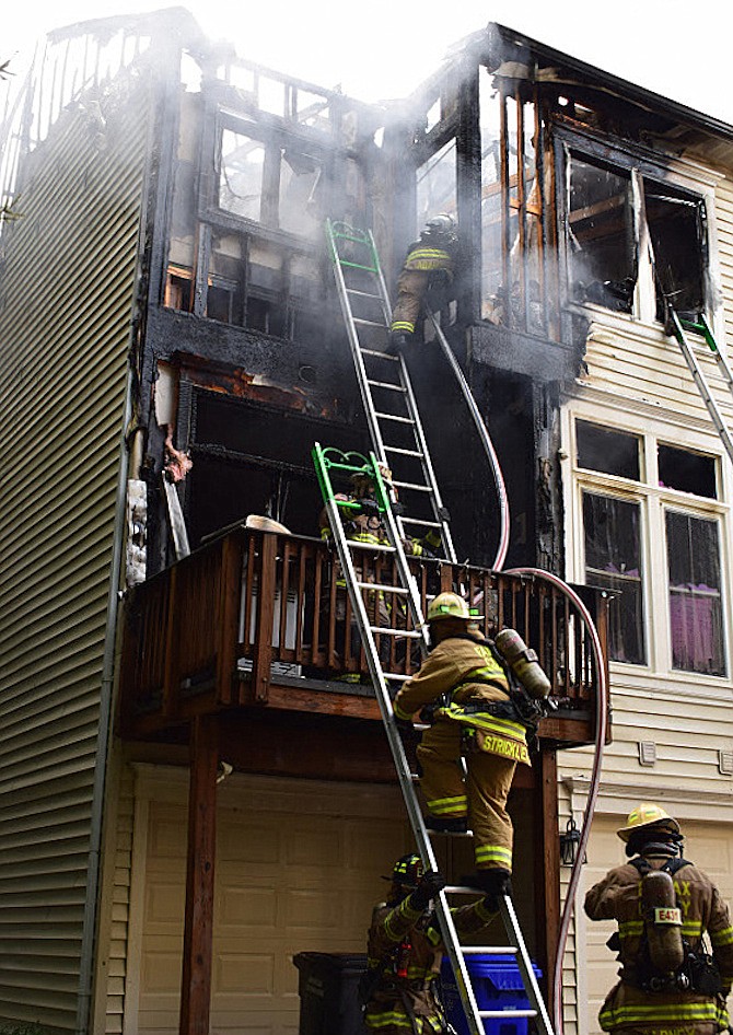 Firefighters climbing up into the building.